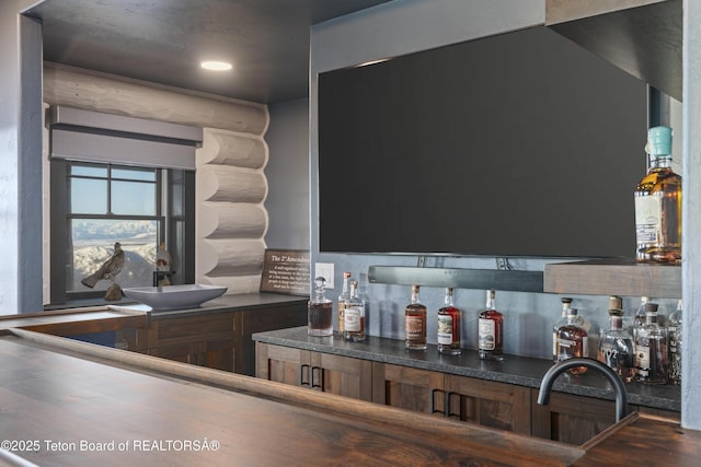 bar featuring indoor wet bar and log walls