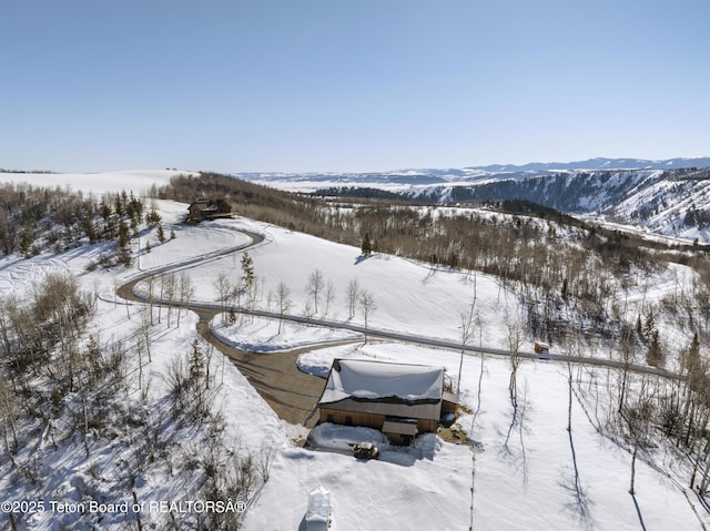 snowy aerial view featuring a mountain view