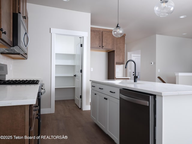 kitchen featuring pendant lighting, sink, white cabinetry, a kitchen island with sink, and stainless steel appliances