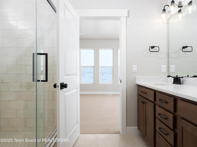 bathroom with an enclosed shower, vanity, and tile patterned flooring