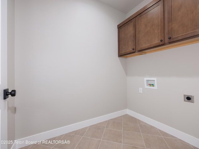 laundry room featuring washer hookup, hookup for an electric dryer, light tile patterned floors, and cabinets