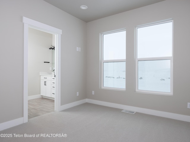 unfurnished room featuring light colored carpet