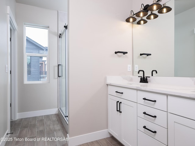 bathroom with an enclosed shower, vanity, and plenty of natural light