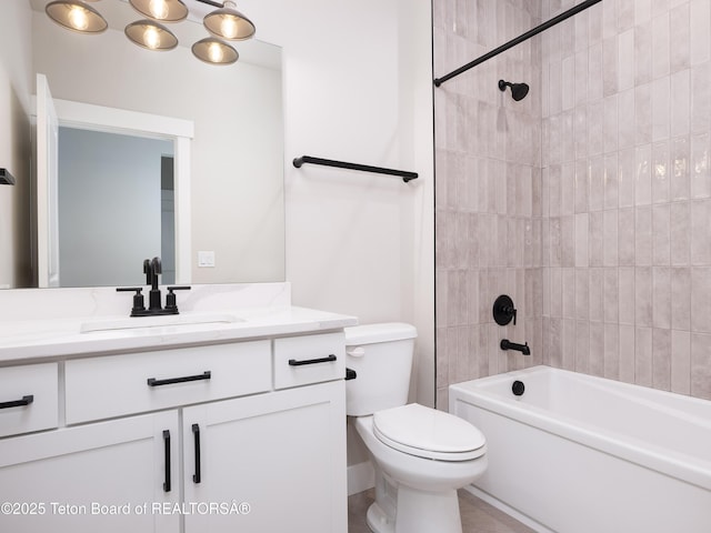 full bathroom featuring toilet, tiled shower / bath combo, and vanity