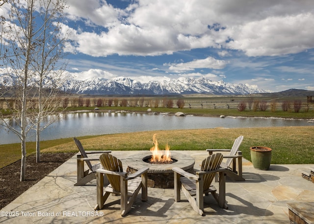 view of patio / terrace featuring an outdoor fire pit and a water and mountain view