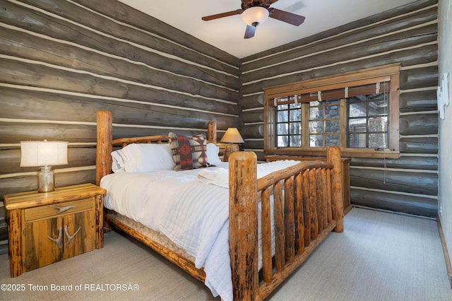 bedroom featuring ceiling fan and rustic walls