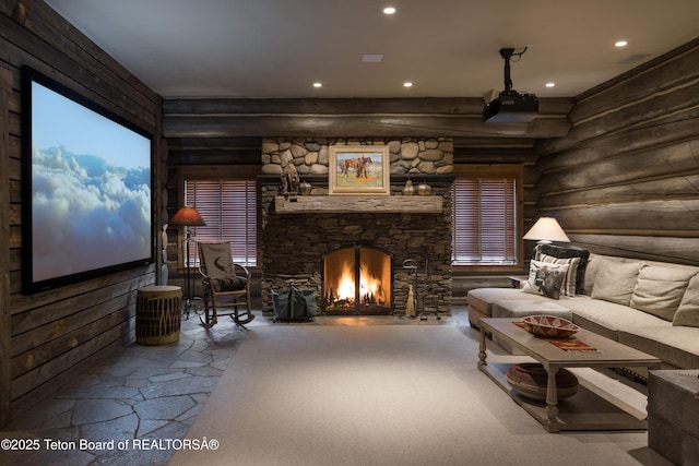 home theater room with rustic walls and a stone fireplace