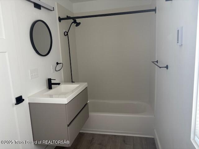 bathroom with vanity, bathing tub / shower combination, and hardwood / wood-style floors