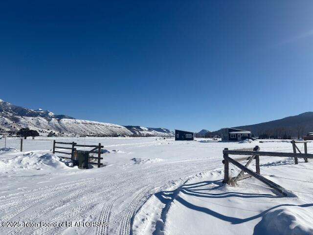 yard layered in snow with a mountain view