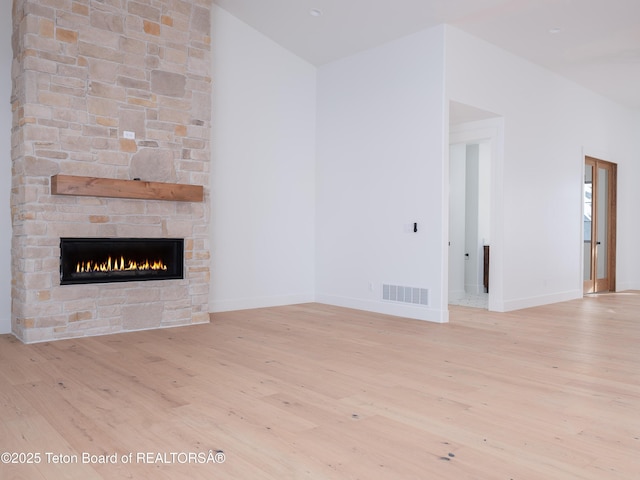 unfurnished living room featuring a fireplace and light hardwood / wood-style flooring