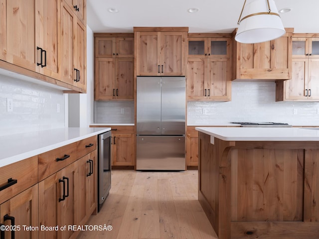 kitchen with wine cooler, tasteful backsplash, decorative light fixtures, light hardwood / wood-style flooring, and appliances with stainless steel finishes