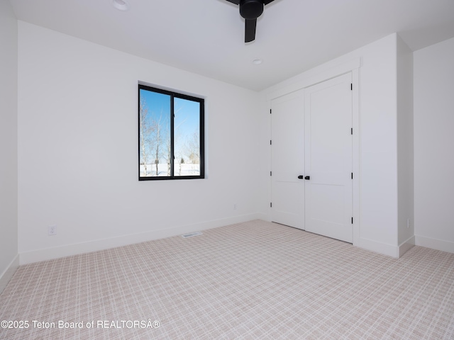 unfurnished bedroom with ceiling fan and a closet