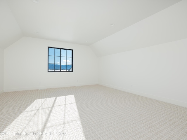 additional living space with lofted ceiling and carpet flooring