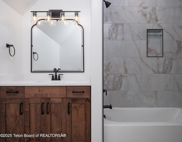 bathroom featuring tiled shower / bath combo and vanity