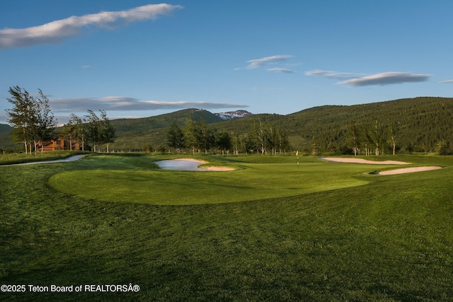 surrounding community featuring a mountain view and a lawn