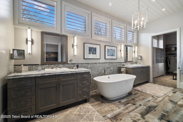 bathroom with vanity, a washtub, hardwood / wood-style flooring, and a chandelier