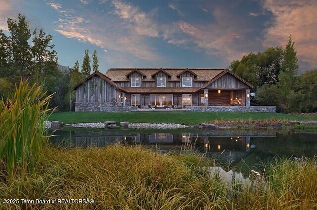 back house at dusk with a lawn