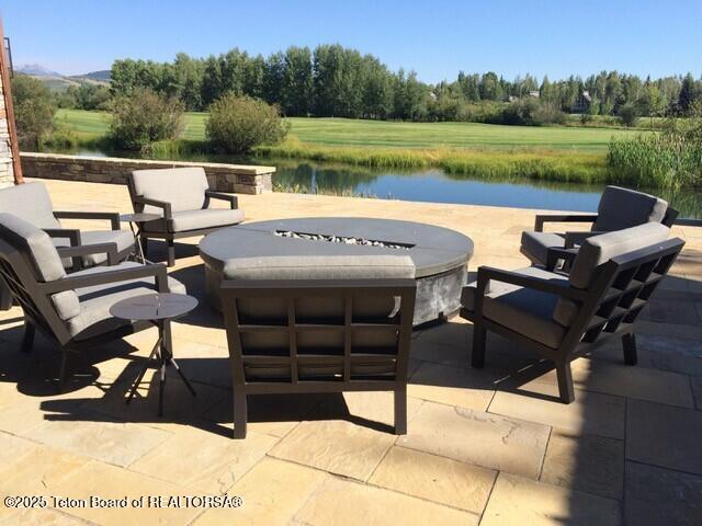 view of patio with a water view and an outdoor fire pit