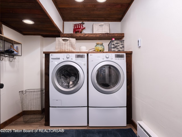 washroom with a baseboard radiator, wood-type flooring, wood ceiling, and washing machine and dryer