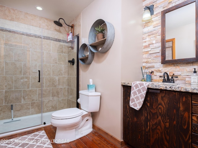 bathroom with vanity, wood-type flooring, an enclosed shower, and toilet