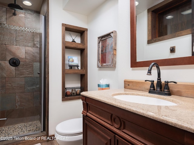 bathroom featuring vanity, an enclosed shower, built in features, and toilet