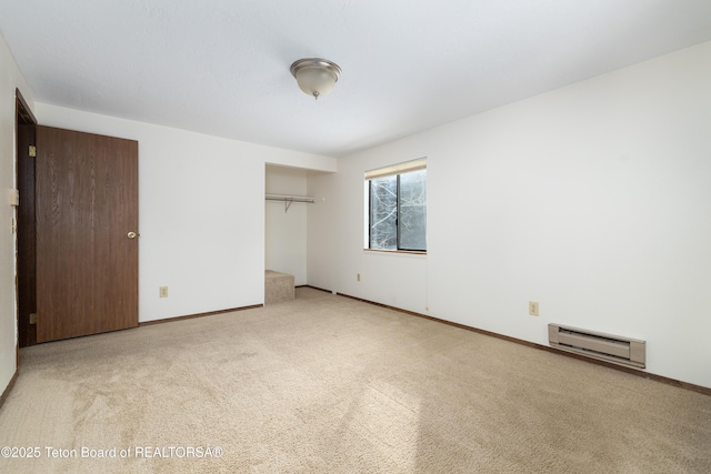 unfurnished bedroom featuring a baseboard heating unit, light carpet, and a closet