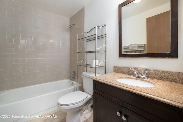 full bathroom featuring vanity, tiled shower / bath, and toilet