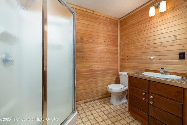 bathroom featuring walk in shower, vanity, toilet, and wood walls