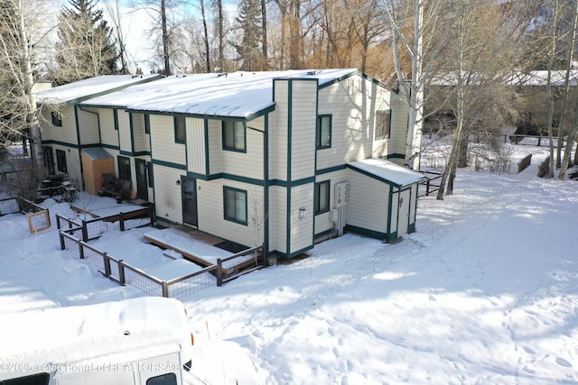 view of snow covered back of property