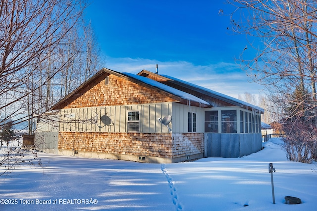 view of snow covered exterior featuring a sunroom