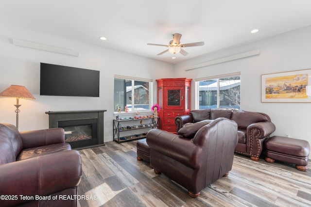 living room featuring wood-type flooring and ceiling fan