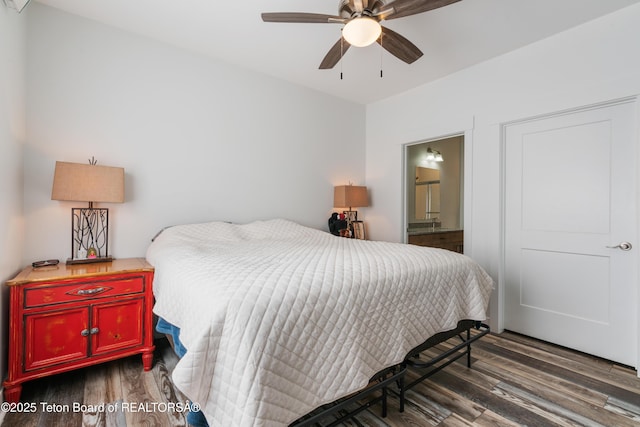 bedroom featuring dark hardwood / wood-style flooring, ensuite bath, and ceiling fan