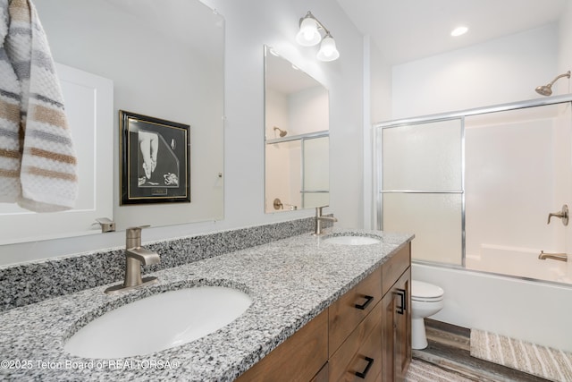 full bathroom with toilet, vanity, bath / shower combo with glass door, and hardwood / wood-style floors