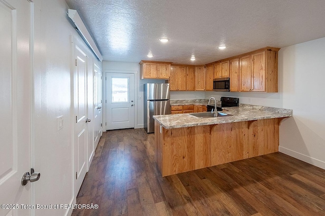 kitchen with dark hardwood / wood-style flooring, sink, a textured ceiling, and appliances with stainless steel finishes