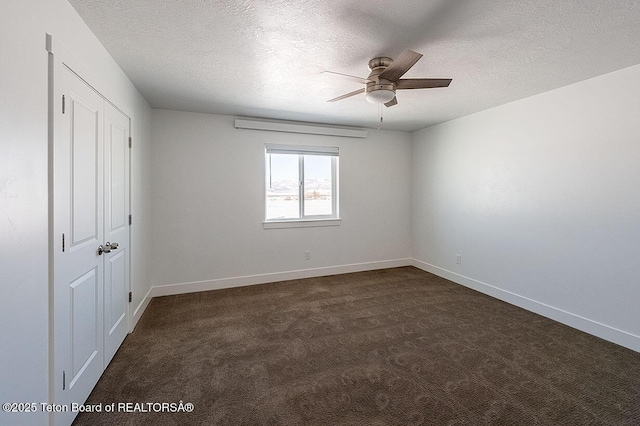 carpeted spare room featuring ceiling fan and a textured ceiling