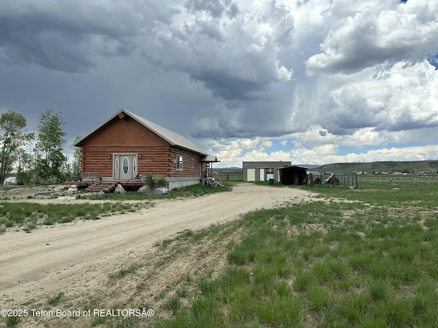 5 Sandy Ln, Boulder, WY 82923 - view of side of property featuring log exterior, dirt driveway, an outbuilding, and a view of rural / pastoral area
