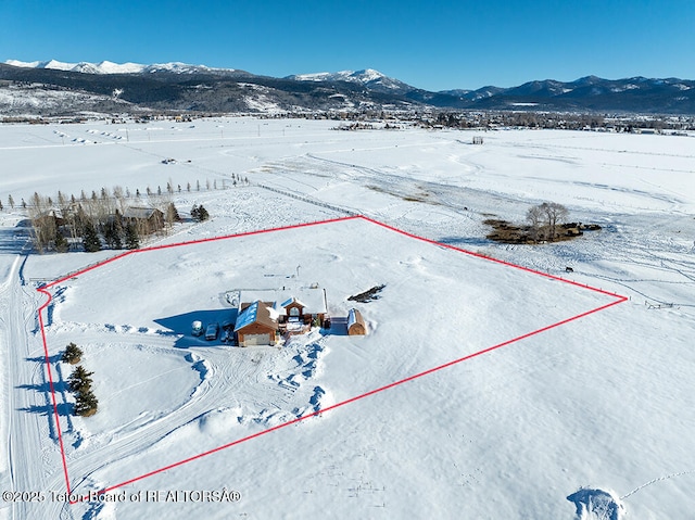 snowy aerial view with a mountain view