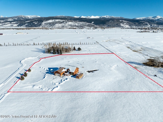 snowy aerial view featuring a mountain view