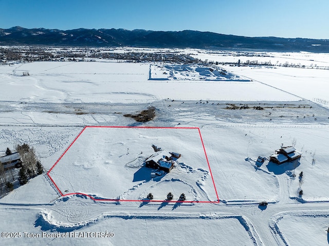 snowy aerial view featuring a mountain view