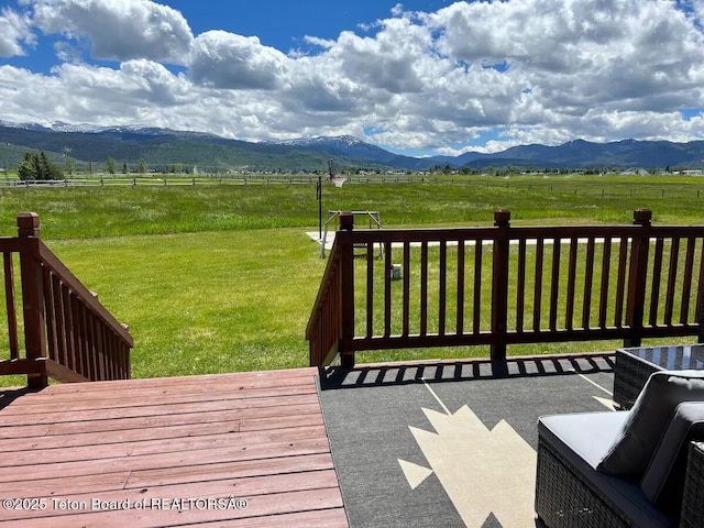 wooden terrace with a rural view, a mountain view, and a yard