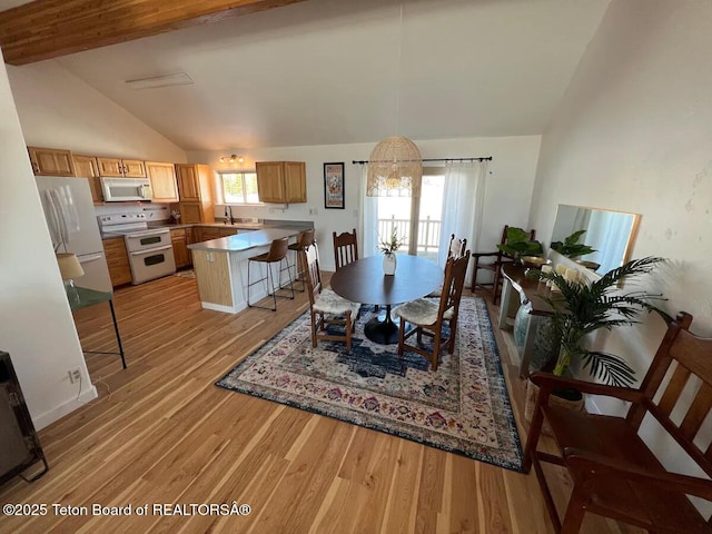 dining room with sink, light hardwood / wood-style flooring, beam ceiling, high vaulted ceiling, and a notable chandelier