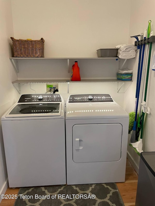 washroom featuring wood-type flooring and washing machine and clothes dryer