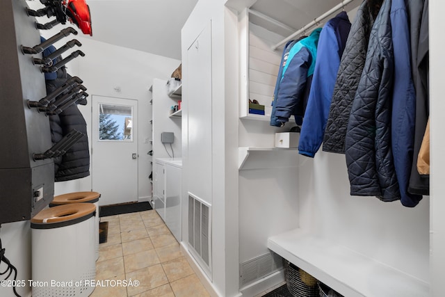 clothes washing area with independent washer and dryer and light tile patterned floors