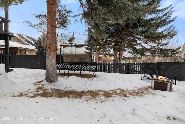 yard covered in snow with a fire pit