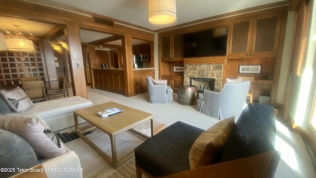 living room featuring built in shelves and a stone fireplace