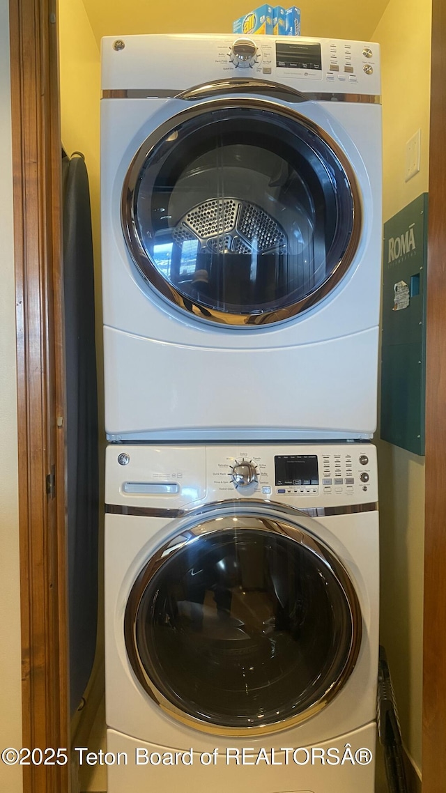 laundry room featuring stacked washer / drying machine