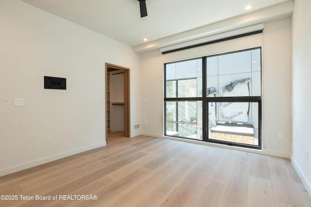 empty room with light hardwood / wood-style flooring and ceiling fan