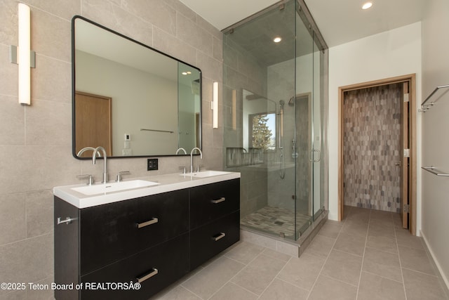 bathroom with tile patterned flooring, vanity, tile walls, and an enclosed shower