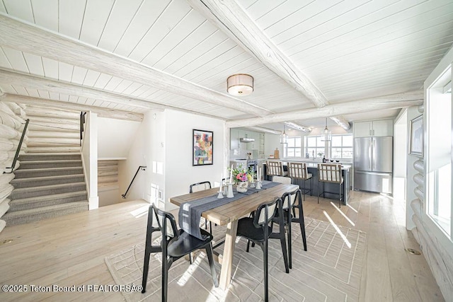 dining room with wood ceiling, beam ceiling, and light hardwood / wood-style floors