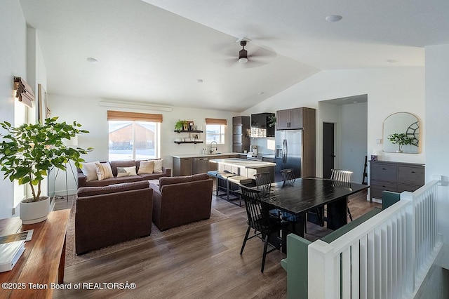 dining room featuring hardwood / wood-style flooring, ceiling fan, vaulted ceiling, and sink